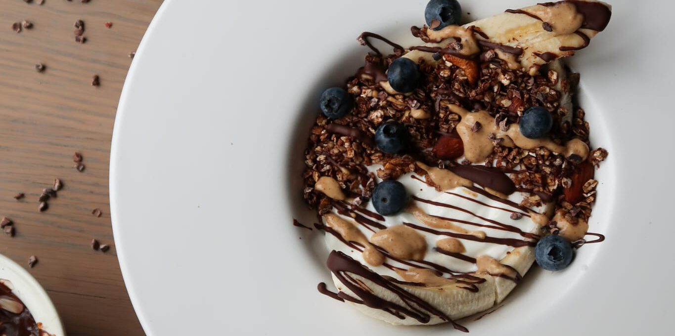 Gezonde Yoghurt Bananensplit met Cacao Amandel Granola, Pure Chocolade Drizzle & Pindakaas